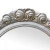 Art-Deco-oval-mirror-with-flowered-decor-carved-wood-pediment